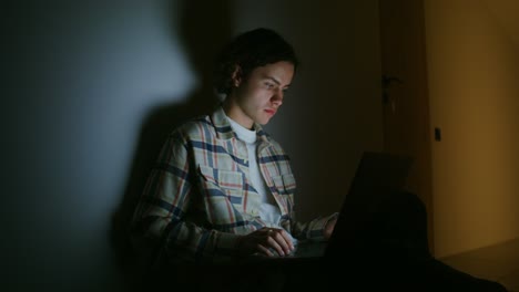 young man working on laptop at night