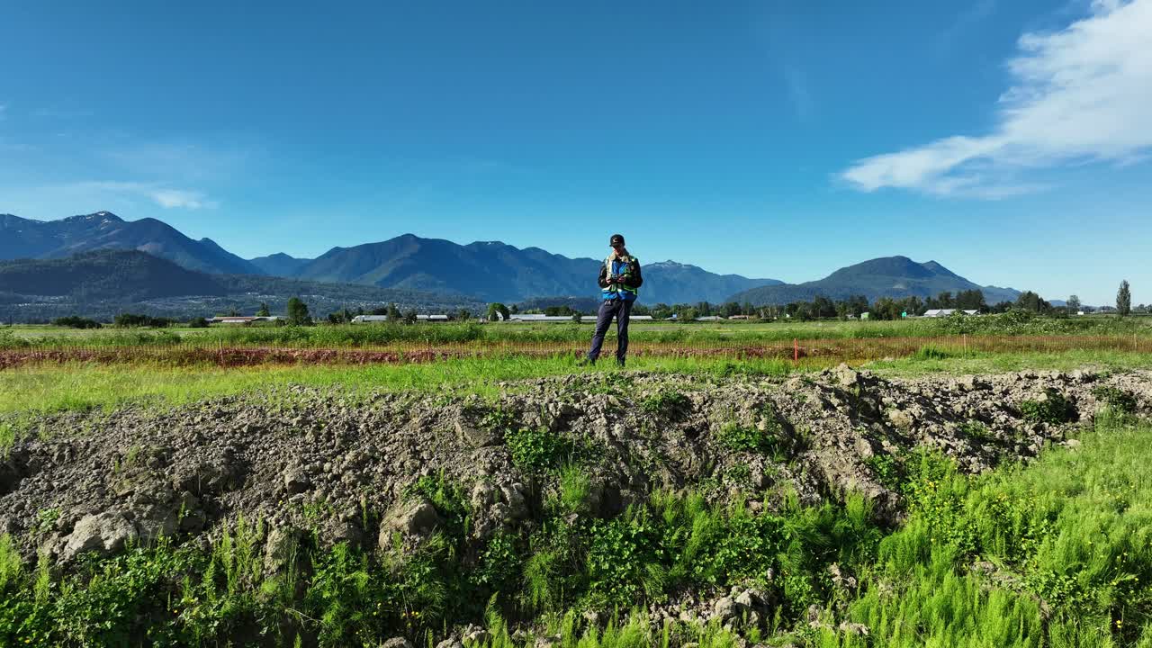 여름 낮에는 푸른 하늘과 산을 배경으로 서 있는 전문 드론 조종사