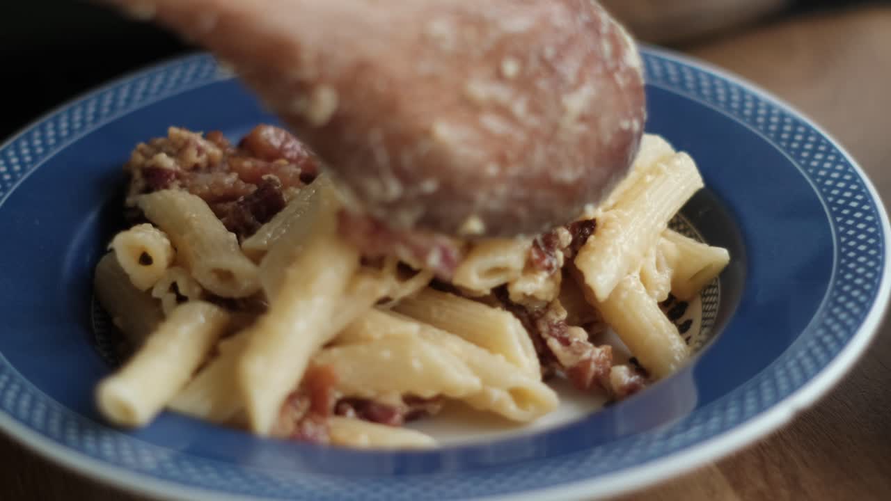 Close-Up of Carbonara Dish Served with a Rustic Wooden Spoon