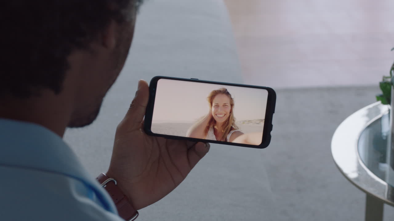 hombre joven chateando en video con su novia en el teléfono inteligente saludando con la mano mujer joven compartiendo vacaciones viaje pareja teniendo una relación a larga distancia