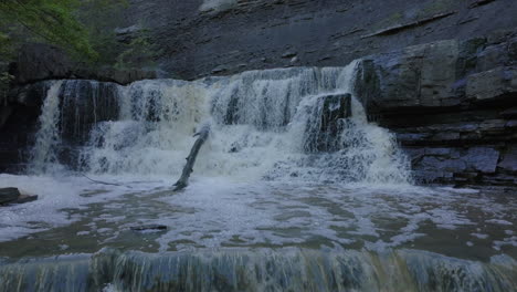 waterfalls with flowing water and foam, surrounded by rocks in ontario's nature