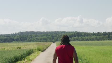 Sansón-Alejándose-De-La-Pantalla-A-La-Distancia-A-Lo-Largo-De-Un-Camino-Viejo-En-Pastos-Verdes,-Personaje-Bíblico-Con-Largas-Rastas,-Guerrero-Y-Juez-Israelita,-Hombre-Negro-En-El-Antiguo-Testamento,-Cristiano