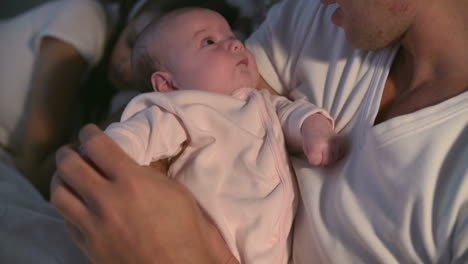 Father-Cuddles-Newborn-Baby-Daughter-In-Bed