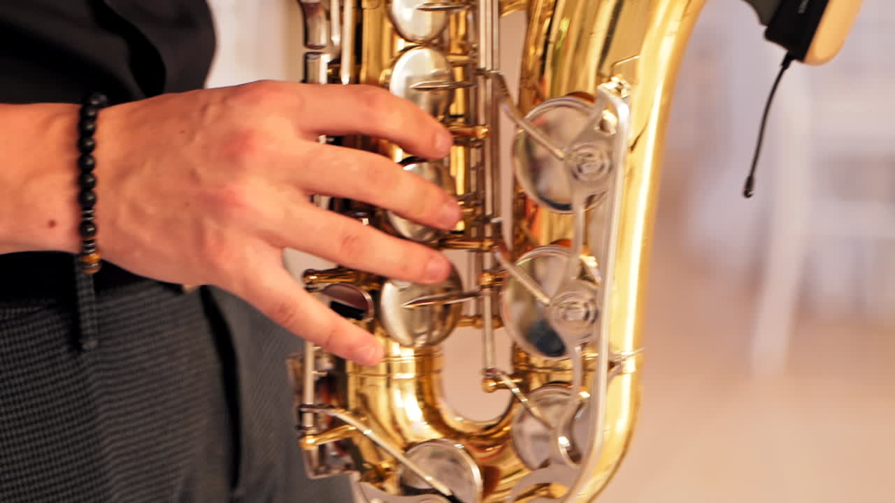 Male saxophonist playing on instrument. Close up view of man playing on saxophone