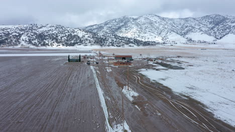 Flying-over-a-wintery,-snowy-farm-in-Tehachapi,-CA