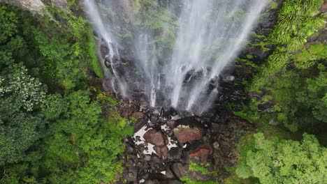 vista espectacular mirando hacia abajo sobre una cascada brumosa de la selva tropical que cae en una exuberante piscina natural verde