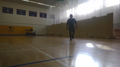 male with headphones walking and crossing himself - strong athletic muscular black man standing on basketball court looking around in 4k