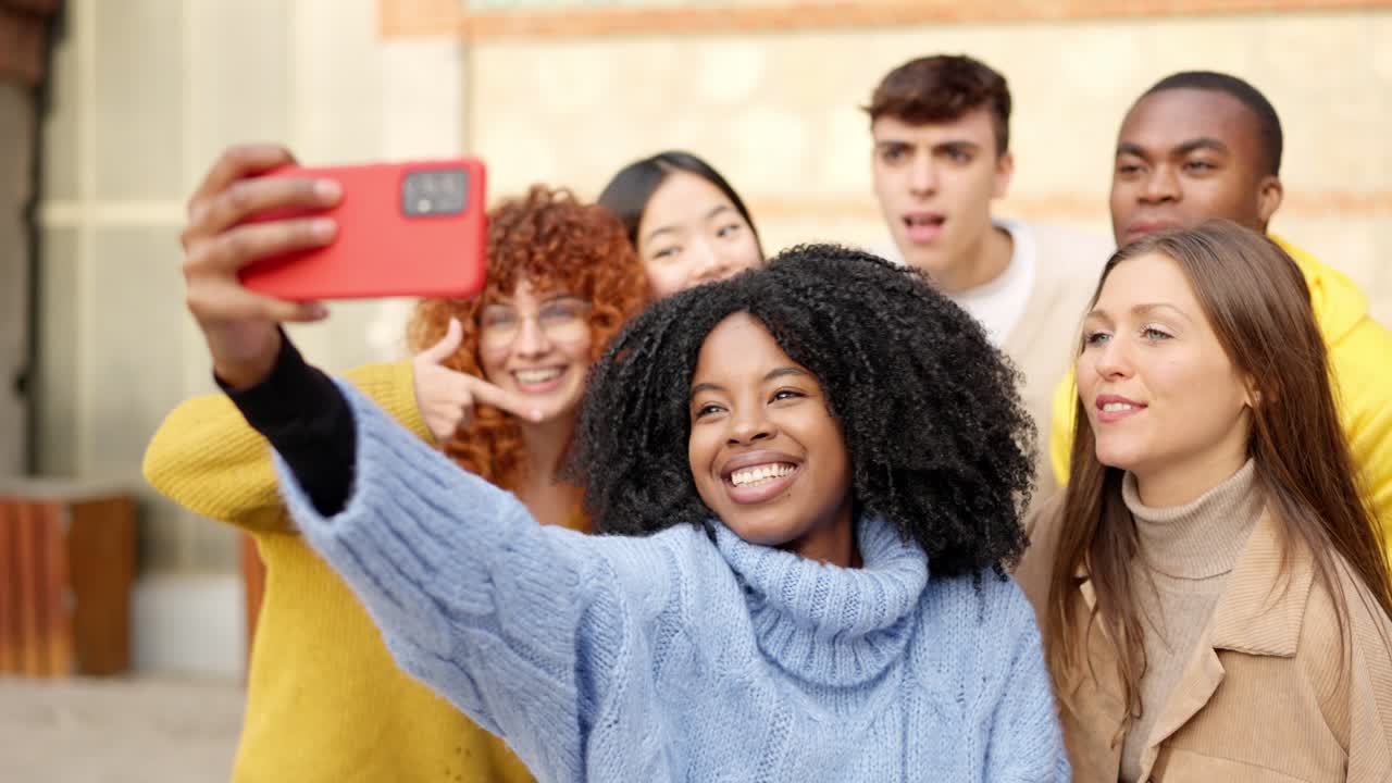 African girl taking a selfie with diverse friends outdoors