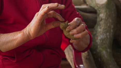 a close-up of skilled hands crafting an animal figure in clay at thanh ha pottery village, a popular tourist destination in vietnam