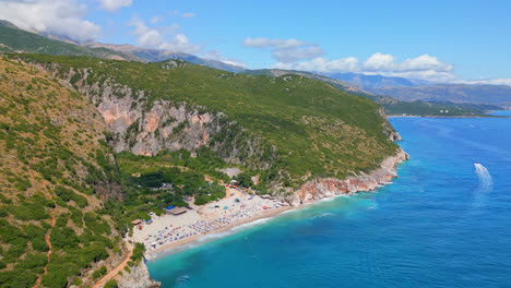 toma aérea en movimiento hacia adelante del agua turquesa del mar jónico a lo largo de la playa de gjipe, albania en un día soleado