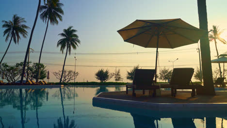 umbrella-with-bed-pool-around-swimming-pool-with-ocean-sea-background---holiday-and-vacation-concept