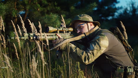 a solider aims his rifle