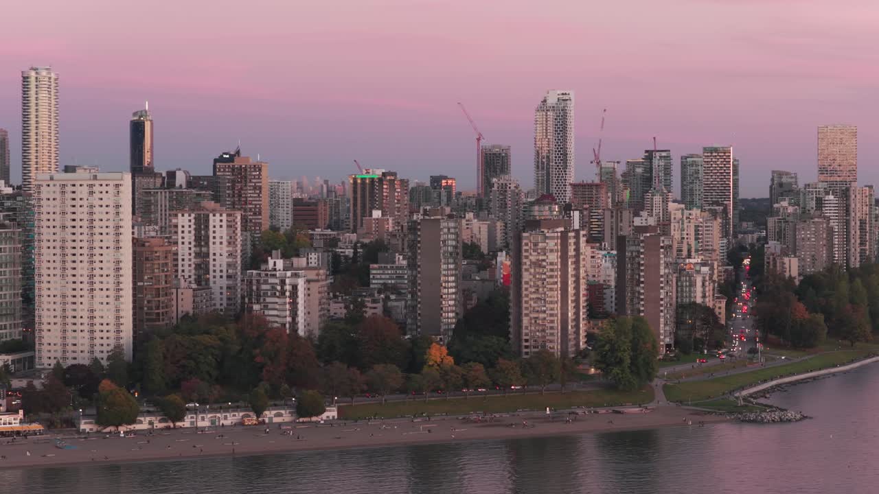 Telephoto wide panning aerial shot of English Bay during sunset in Vancouver, British Columbia, Canada. 4K