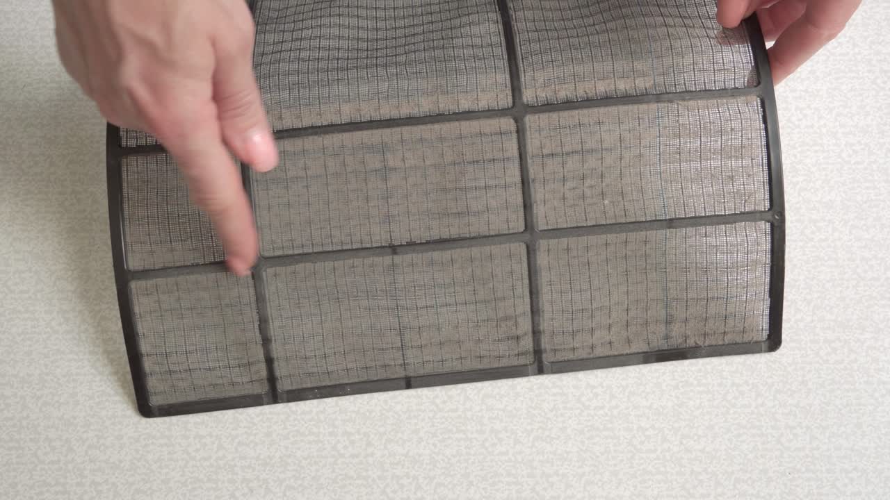 se retira el filtro de aire sucio del aire acondicionado doméstico.