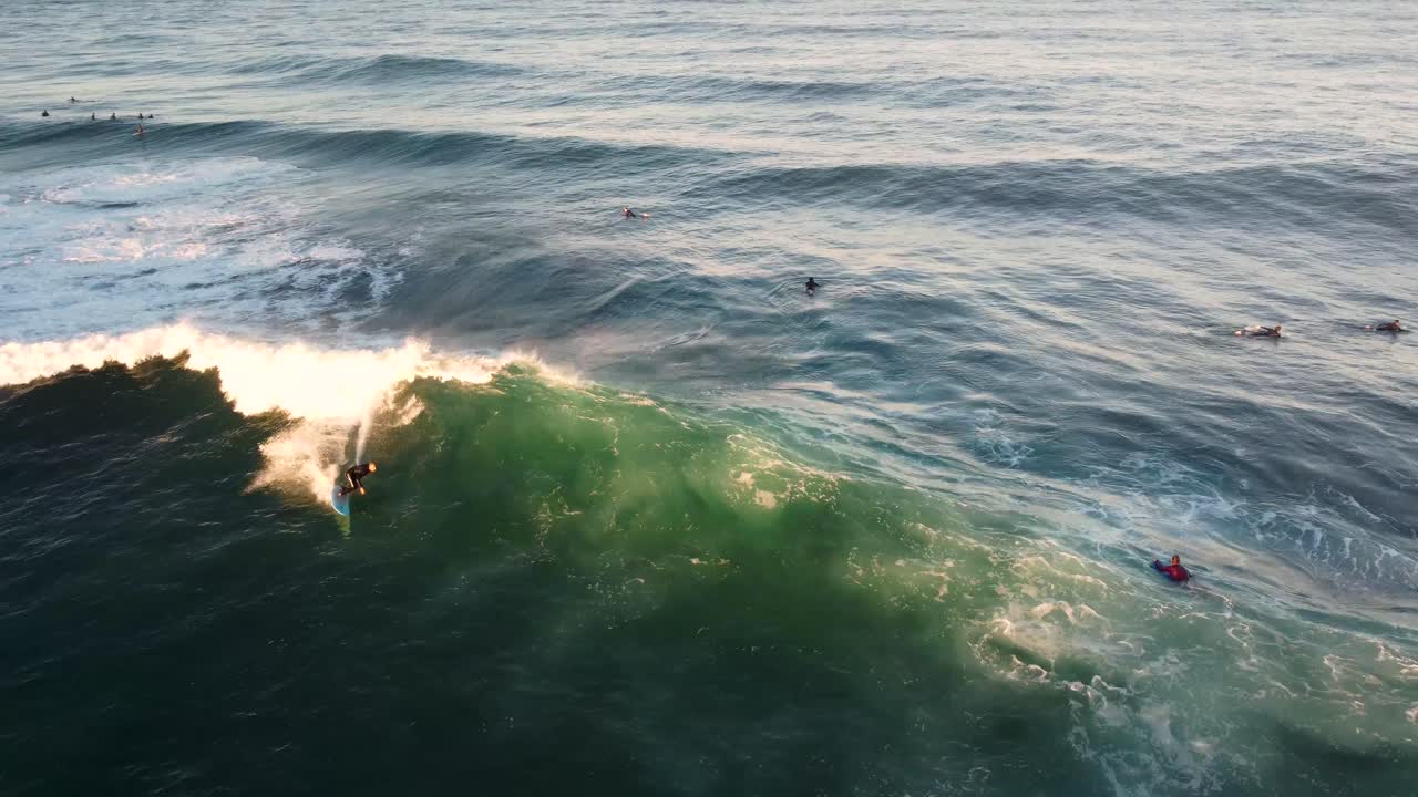 Ripresa aerea con drone di un surfista che esegue un cutback su un'onda oceanica beach break con banco di sabbia nell'Oceano Pacifico, North Avoca, Central Coast NSW Australia 4K