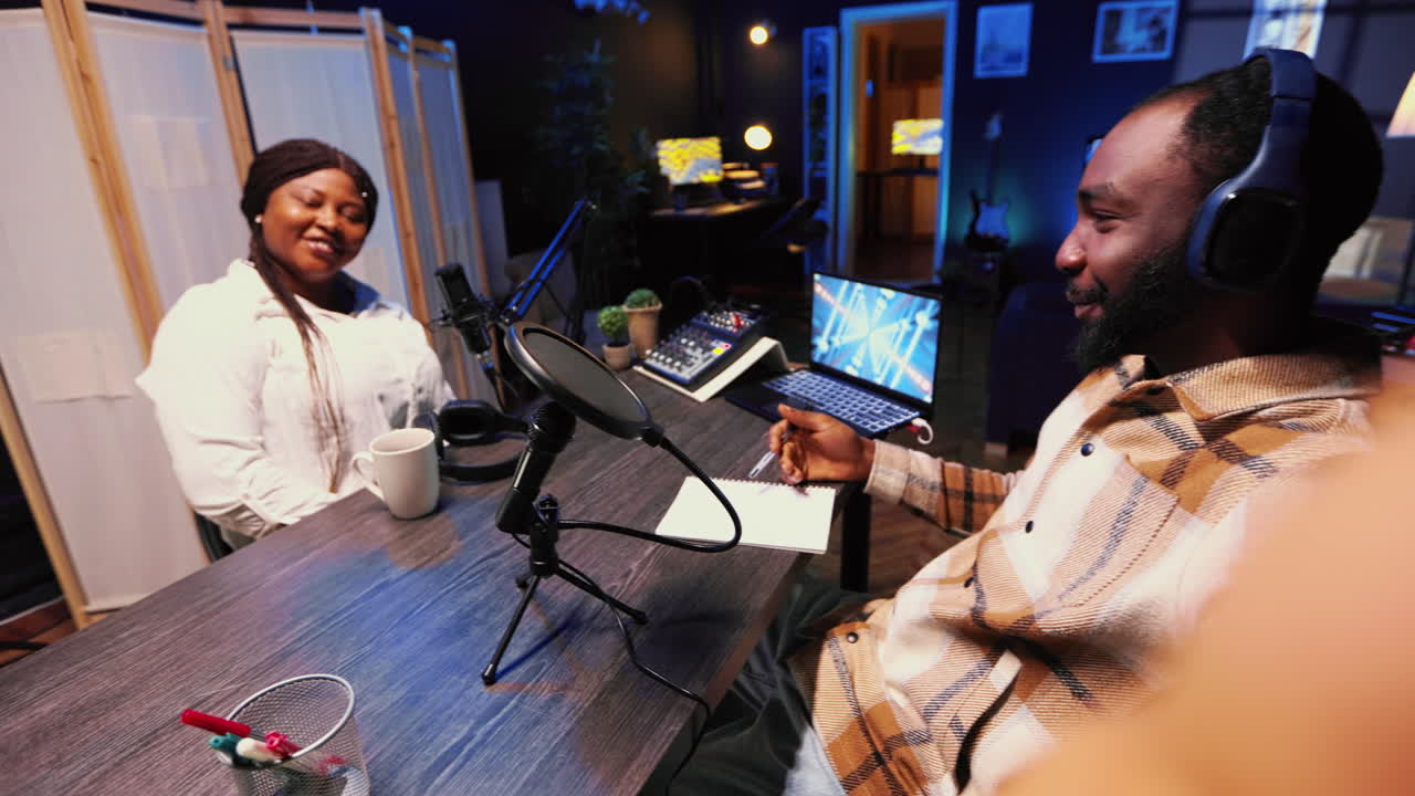 Journalist records interview with selfie camera smartphone in studio, reviewing notes