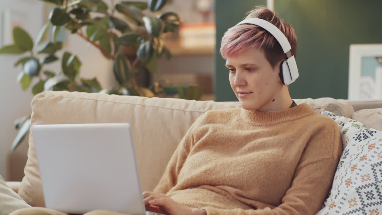 Woman Relaxing and Working on Laptop at Home