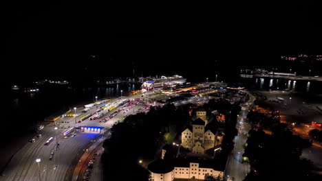 drone flying over the turku castle, approaching the cruise port, night in finland