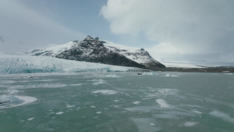 lago congelado helado durante el invierno nevado en islandia - sobrevuelo aéreo