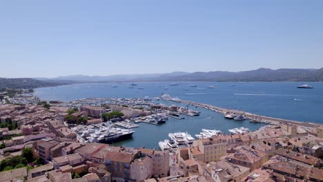 aerial forward flight over city of saint tropez with harbor and luxury yachts in summer
