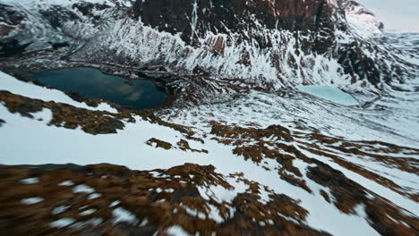 snow-covered mountain slopes on senja island with lakes and rocky peaks