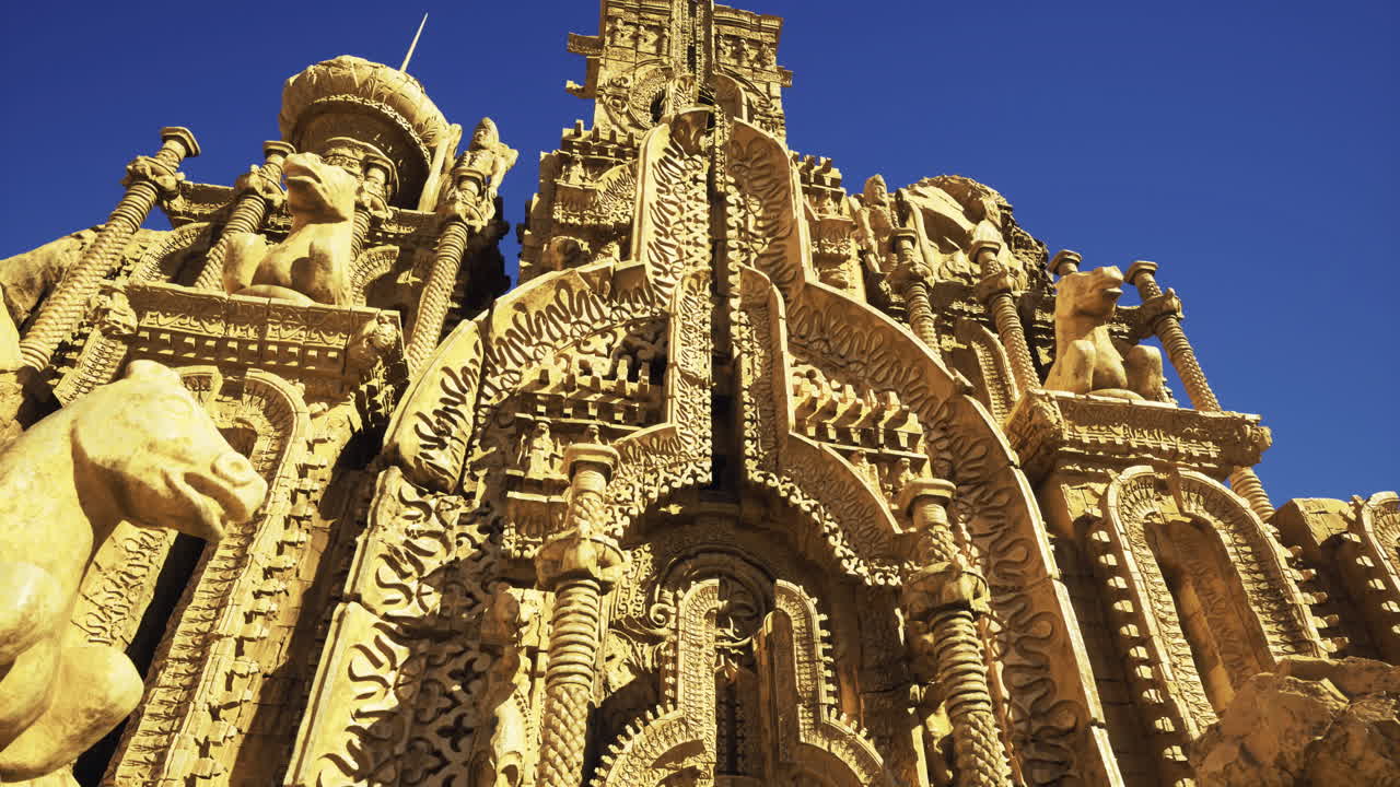 Intricate stone structure with carvings and animals under a clear sky