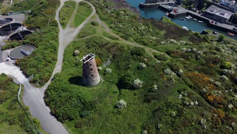 amlwch port red brick disused abandoned windmill aerial view north anglesey wales rising top down shot