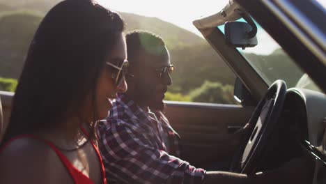 african american couple using map while sitting in convertible car