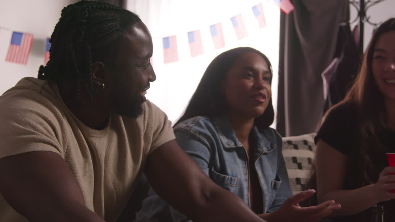 amigos en casa celebrando con la fiesta por el día de la independencia de estados unidos el 4 de julio hablando y comiendo bocadillos