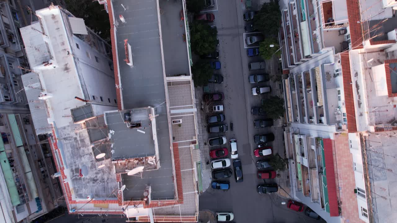 Vista dall'alto con drone ad alta quota che sorvola edifici residenziali e strade urbane a Salonicco.