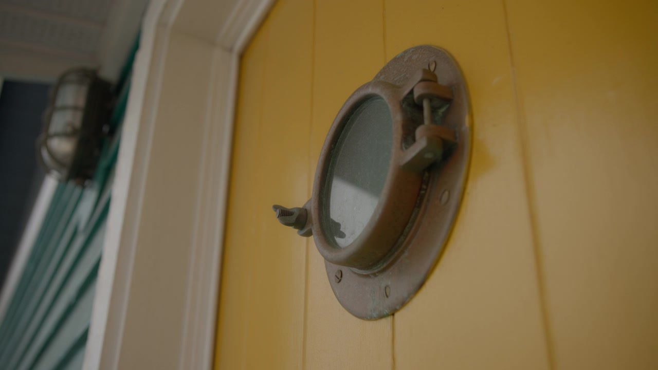 Close up of a round window in the floating house wall in Victoria harbour
