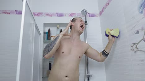 man singing in the shower with a sponge