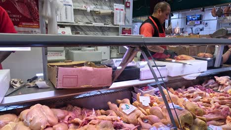 carnicero cortando pollo en el puesto del mercado de florencia