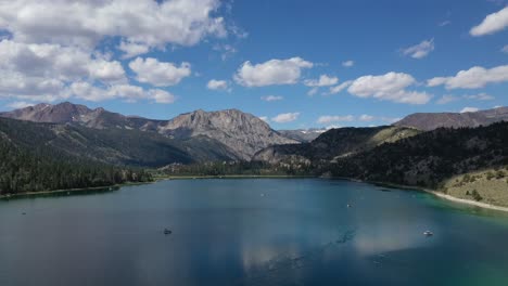 lago de montaña contra el cielo azul nublado en junio lago california, ee.uu. - retroceso aéreo