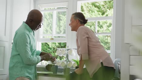 pareja de alto nivel con camisas y preparando café en la cocina
