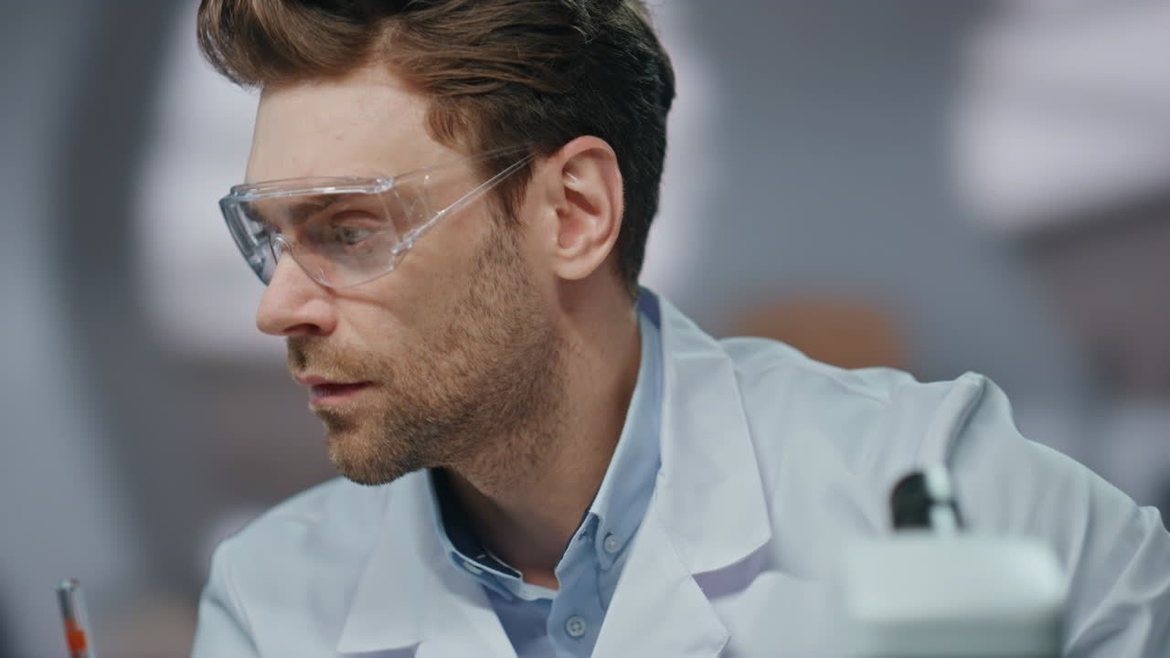 médico ocupado trabajando en el laboratorio mirando al microscopio de cerca. científico serio