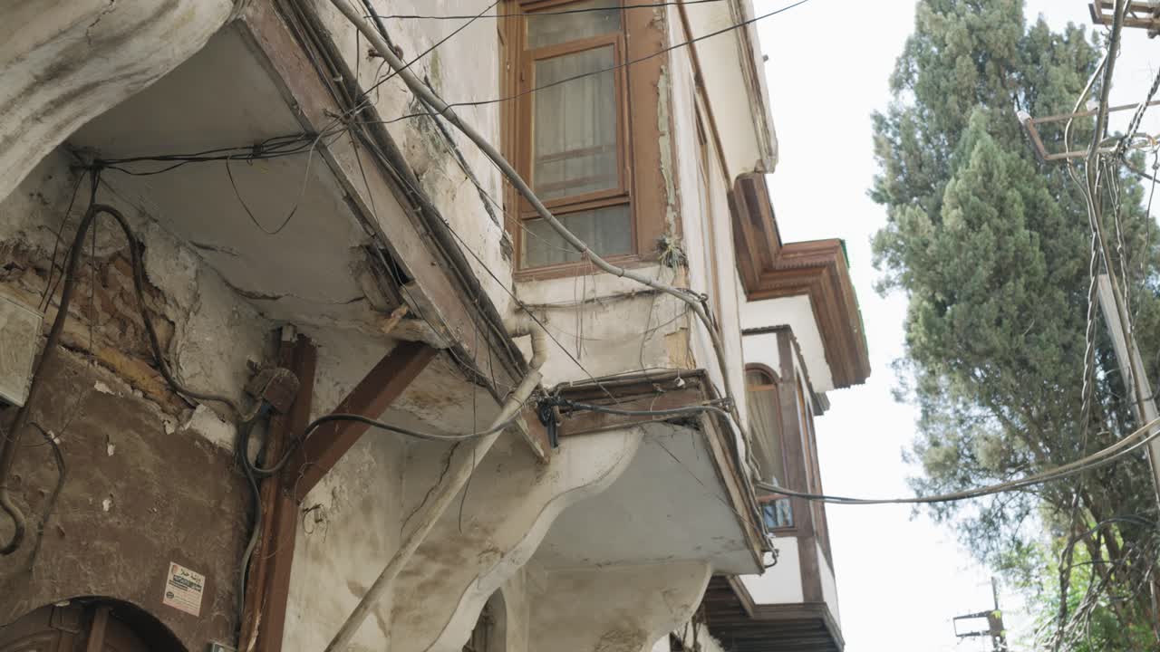 Handheld upward tilt of a historic building in Damascus Old City, Syria, showing aged stone walls, traditional architecture, and authentic Middle Eastern heritage