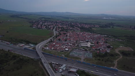 drone flying forward above highway to suburb