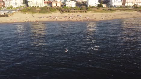 Antena-Orbitando-Alrededor-De-Una-Persona-A-Bordo-De-Sup-Remando-Sobre-Las-Aguas-Del-Mar-A-Lo-Largo-De-La-Playa-De-Punta-Del-Este,-Uruguay