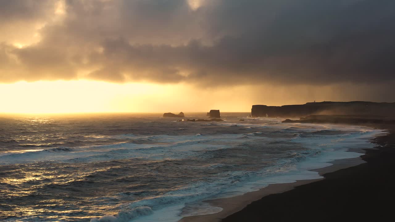 Captivating Aerial Views of Iceland's Black Sand Beach, Showcasing Powerful Waves Amidst the Sunset Haze