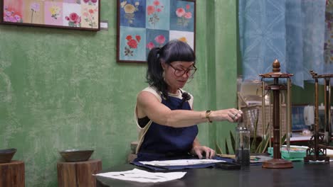 artist painting orchids using traditional chinese techniques, focused and creative work