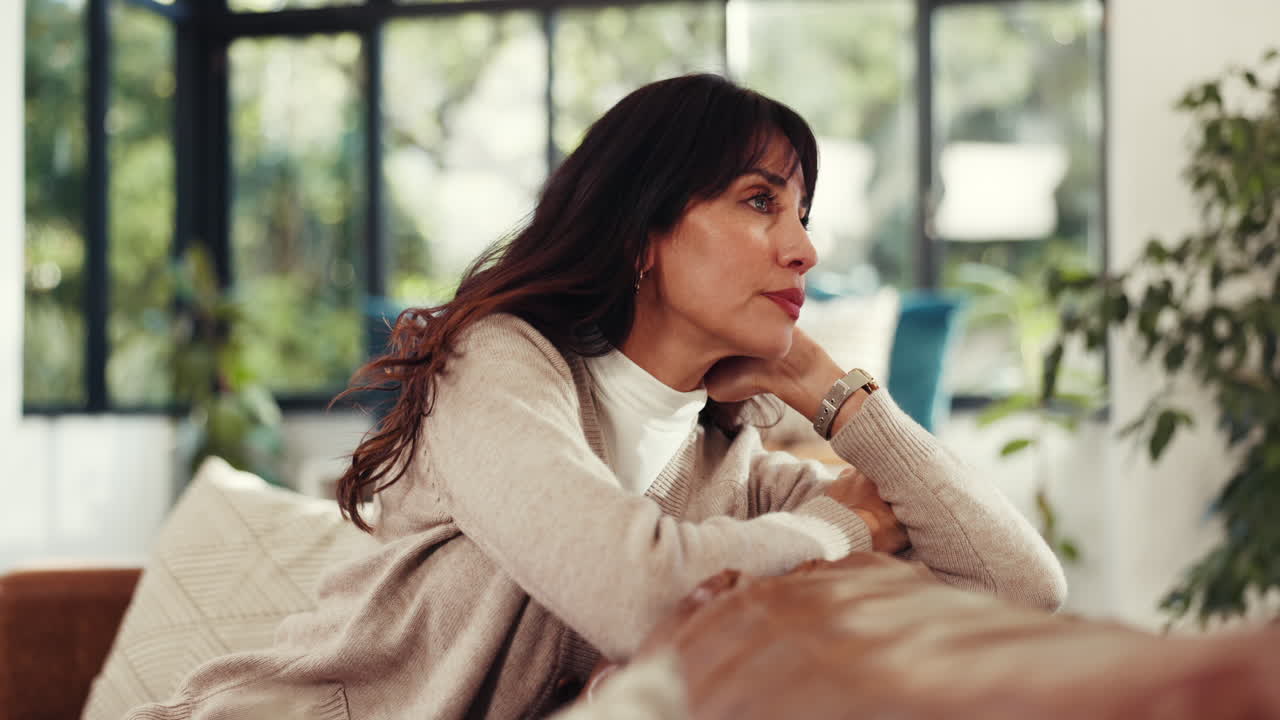 Pensive Woman Sitting on Sofa at Home