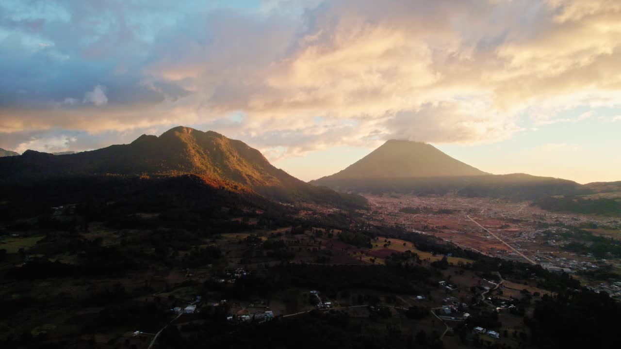 Drone luftfoto af overskyet solnedgang i den gyldne time over guatemalanske vulkaner