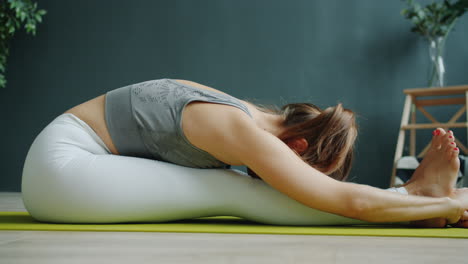 woman practicing seated forward bend yoga pose
