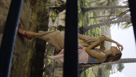 pedestal down shot of pensive blonde woman sitting on abandoned house wall