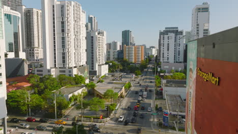 Luftaufnahmen-Von-Fahrzeugen,-Die-Auf-Straßen-In-Modernen-Wohnbezirken-Fahren.-Wohnhochhäuser,-Die-Von-Der-Untergehenden-Sonne-Beleuchtet-Werden.-Miami,-USA