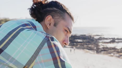 feliz hombre biracial mirando lejos en el paseo marítimo por el mar, cámara lenta
