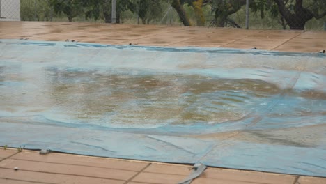 Raindrops-fall-on-pool-tarpaulin-in-early-autumn