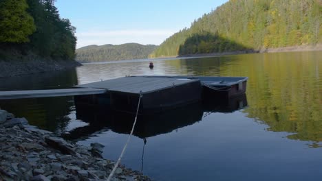 idyllic panoramic view of a big lake with mountains in the background and a wooden landing stage in the foreground-2