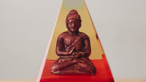 bronze buddha idol seated in meditative pose revealed in cinematic lighting